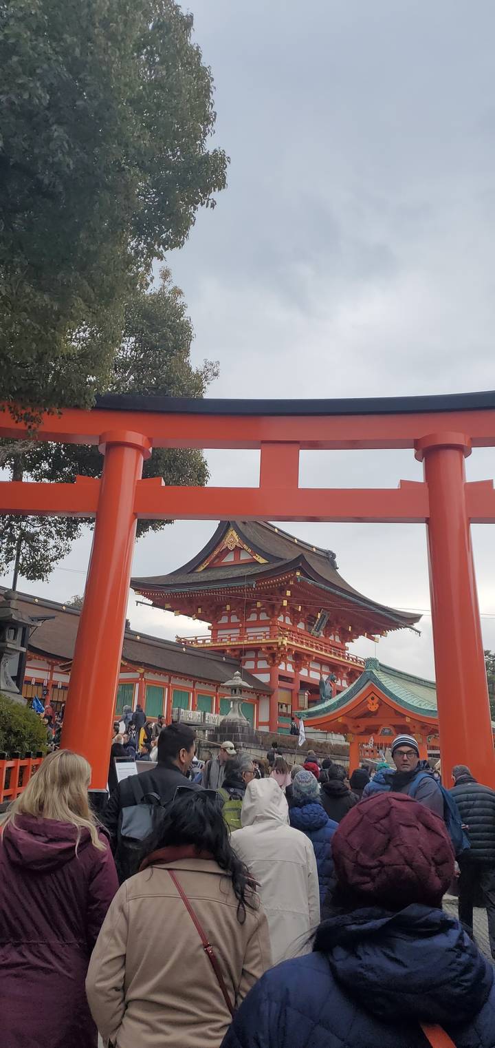 Tourists exploring the famous Fushimi Inari Shrine with its iconic red gates.
