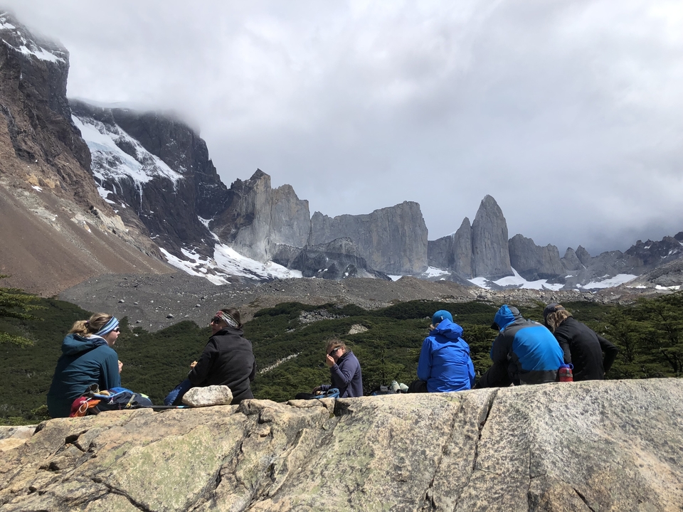 Group of people sitting and admiring the mountains in Patagonia.