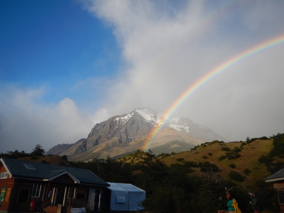 A rainbow arcing over a snow-capped mountain.