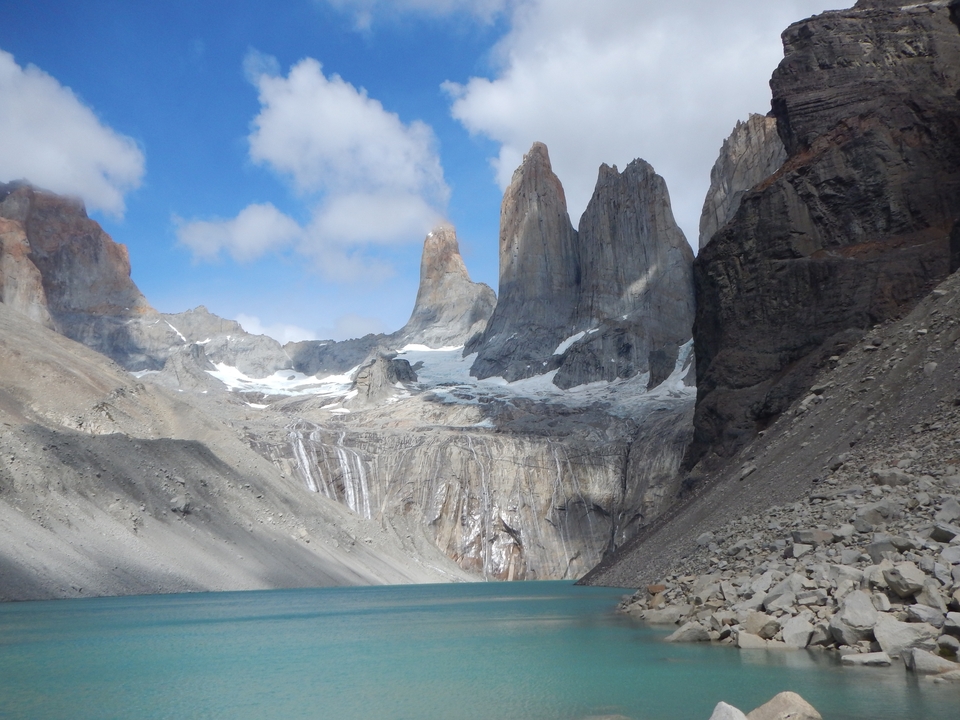 Mountain landscape with sharp rock formations and a glacial lake.