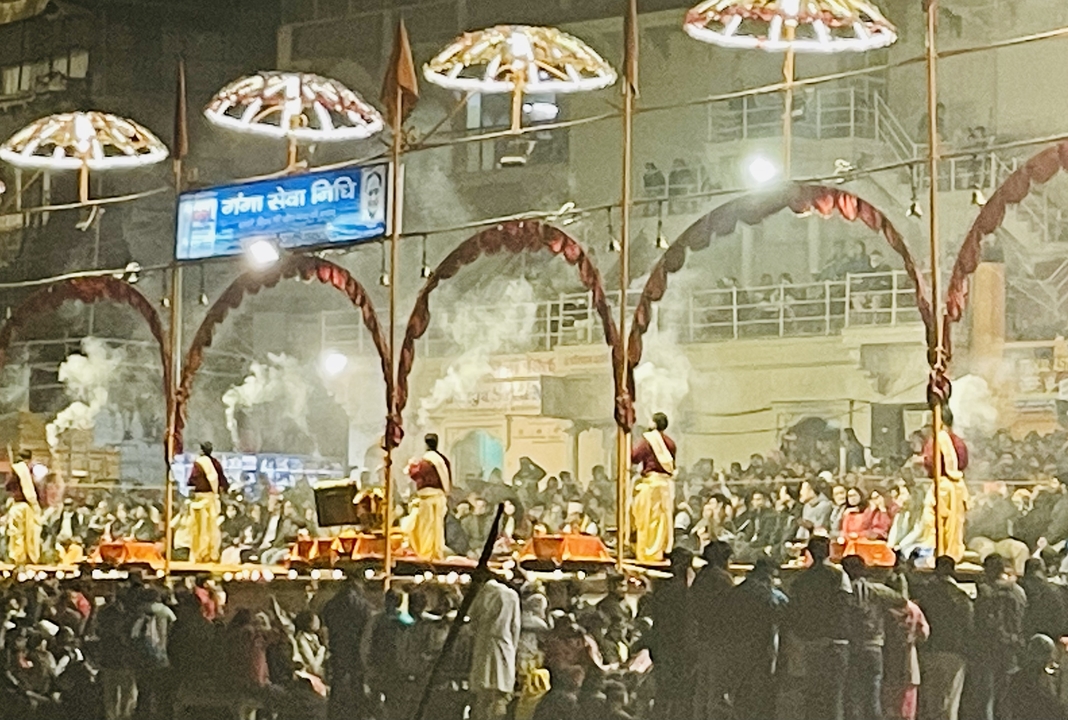 Night scene with people performing rituals on a platform.