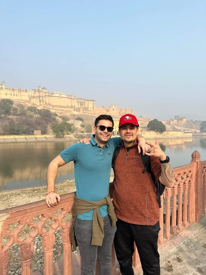Deux personnes devant un fort historique au bord d'une rivière.