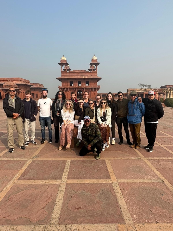 Groupe de touristes posant devant un bâtiment historique.