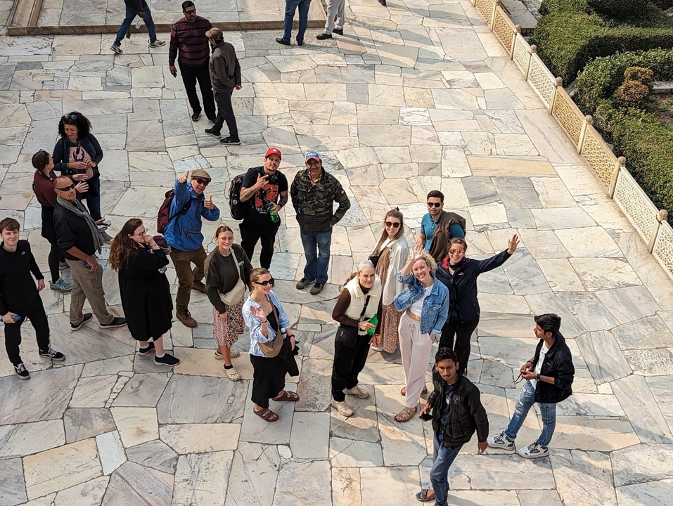 Groupe de touristes posant sur un pavage de pierre.