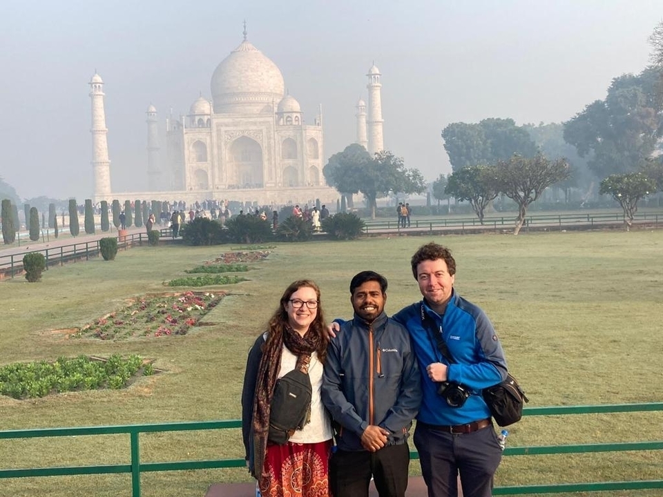 People posing in front of the Taj Mahal.