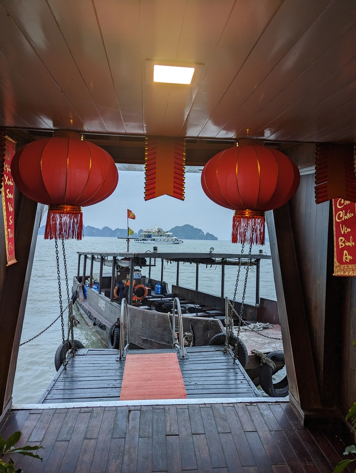 Vue depuis un bateau avec des lanternes suspendues, surplombant la baie d'Halong.