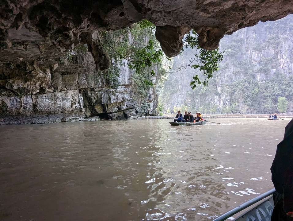 Des touristes naviguant en bateau à travers une grotte fluviale.