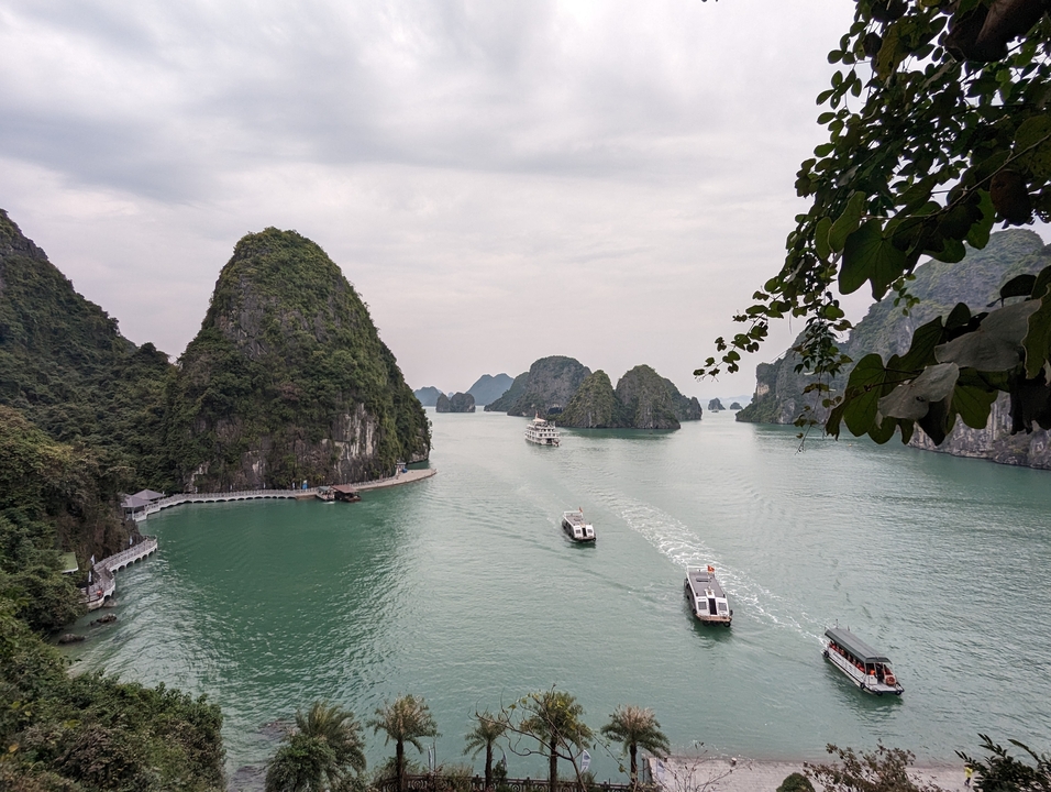 Vue panoramique de la baie d'Halong avec des bateaux et des îles calcaires.