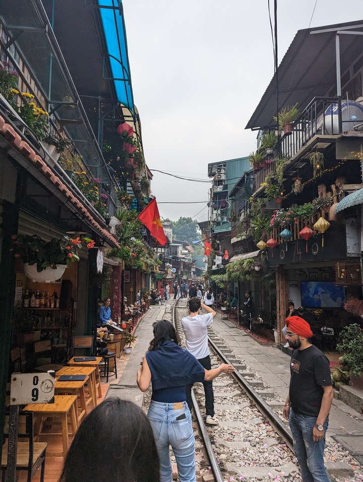 Rue animée avec des magasins et des drapeaux vietnamiens.