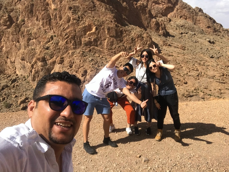 Een groep mensen die poseren in een rotsachtig landschap.