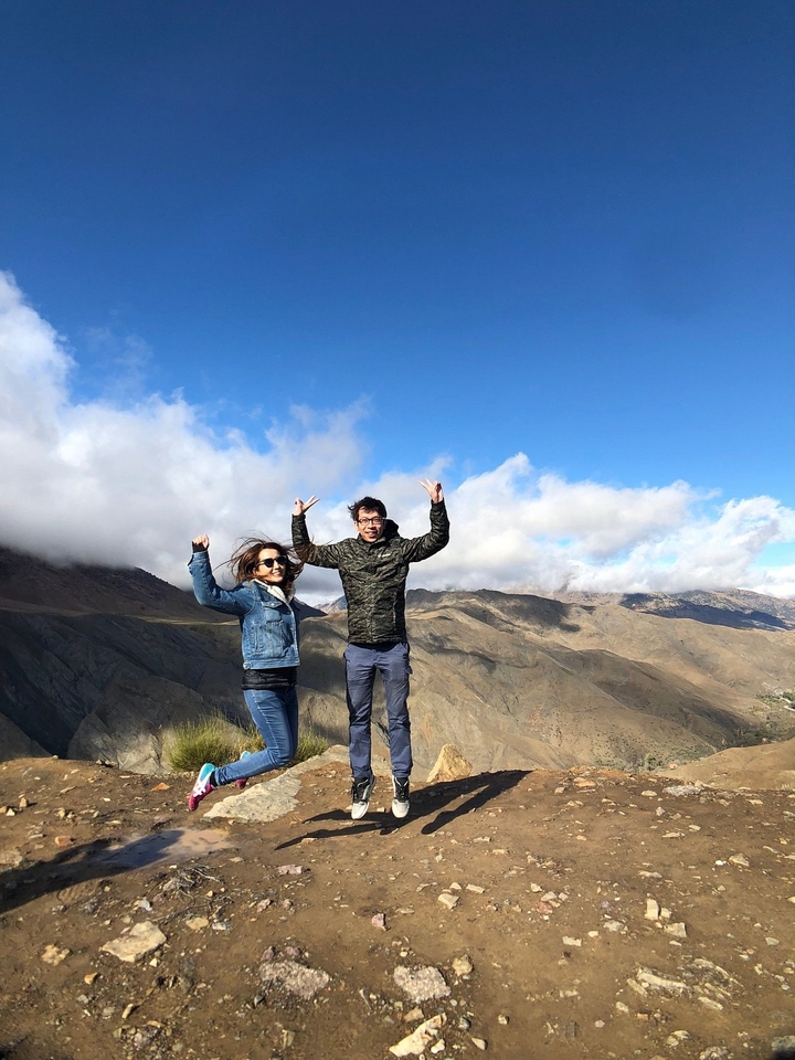 Twee mensen poseren met bergen op de achtergrond.