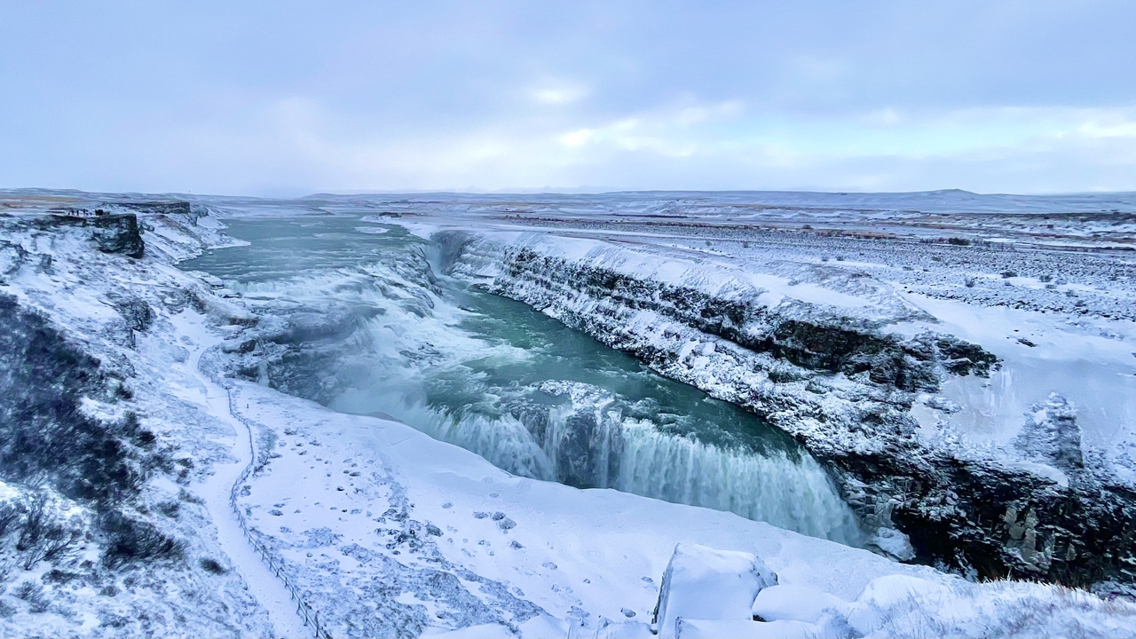 Massive waterfall with icy surroundings in winter.