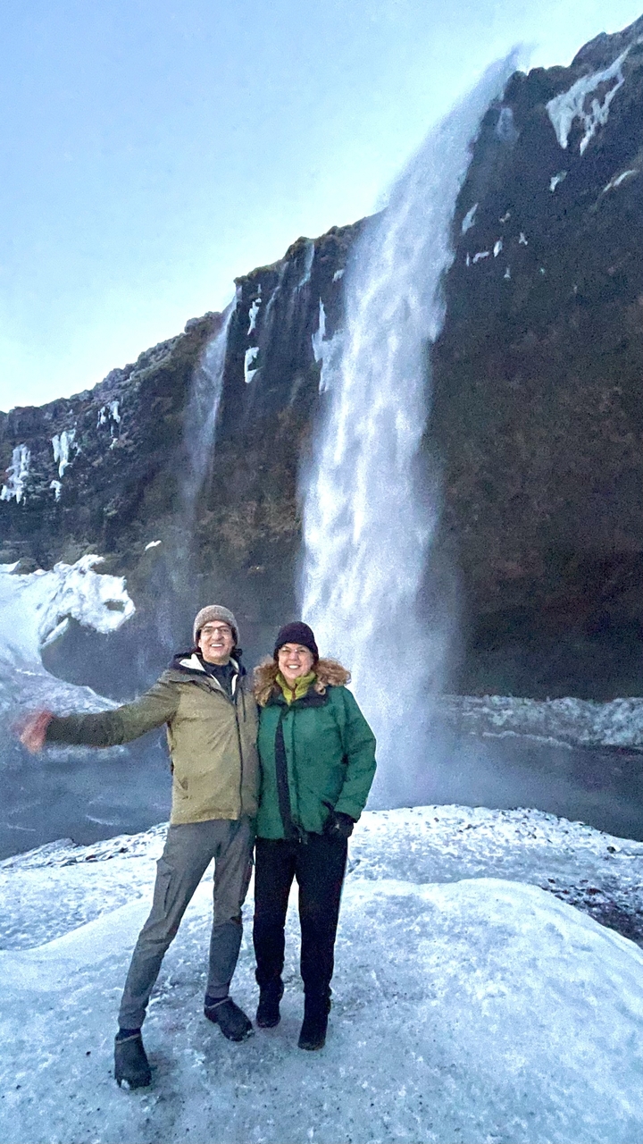 Couple posing with a waterfall in the background.