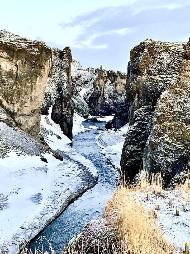 Frozen river winding through a snowy canyon.