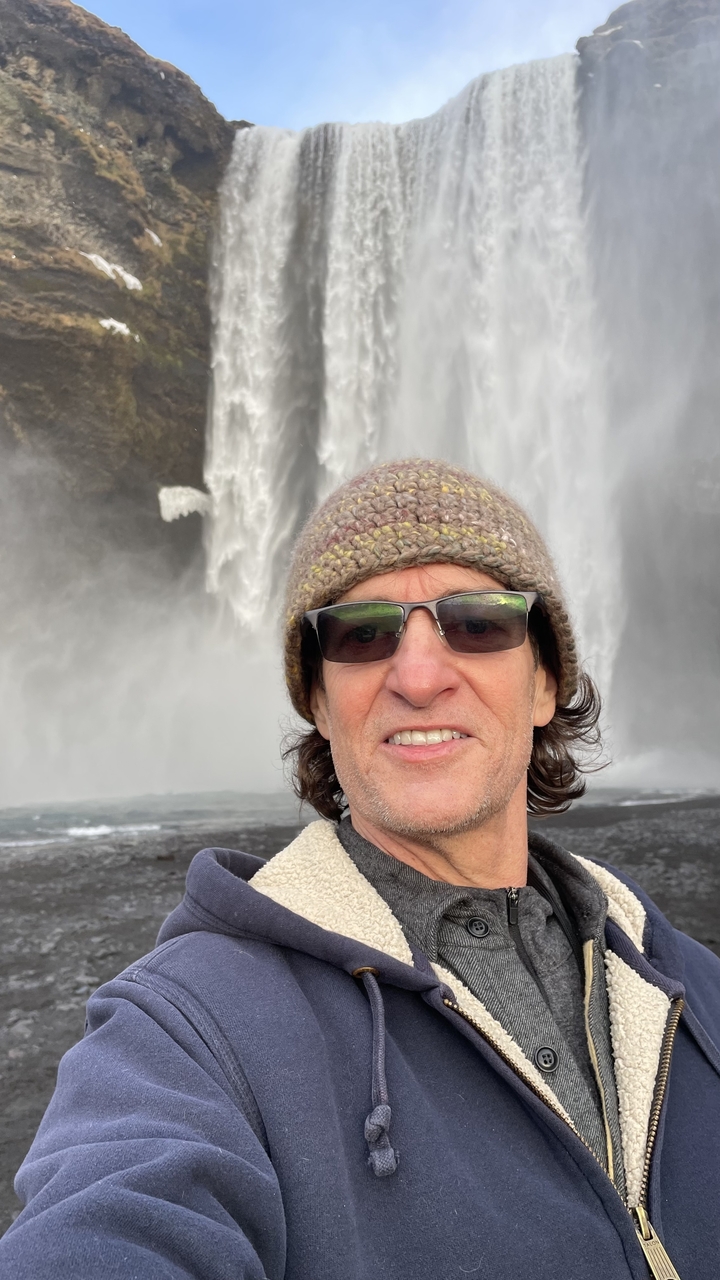 Selfie of a person with a waterfall in the background.