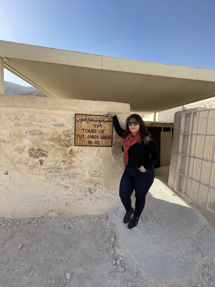 Person posing at the entrance to the Tomb of Tutankhamun.
