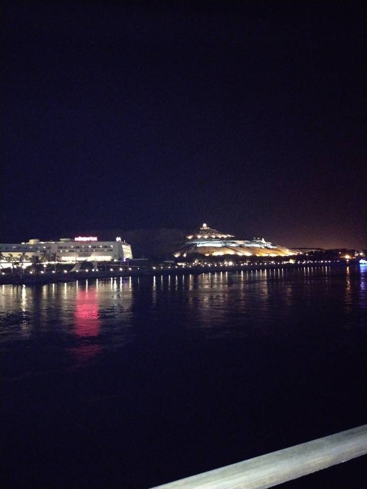 Illuminated building by the water at night.