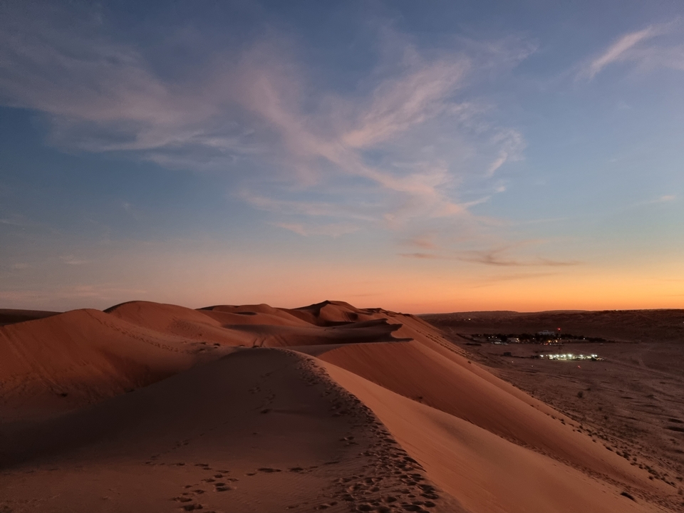 Desert landscape with sand dunes at sunset.