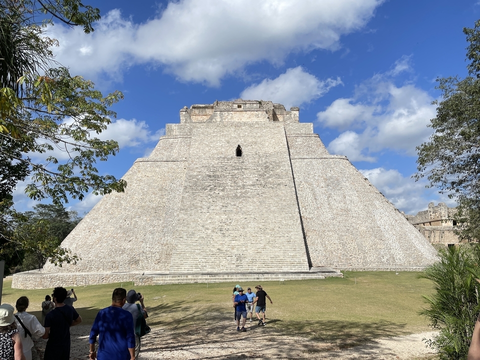 Large Mayan pyramid with tourists nearby.