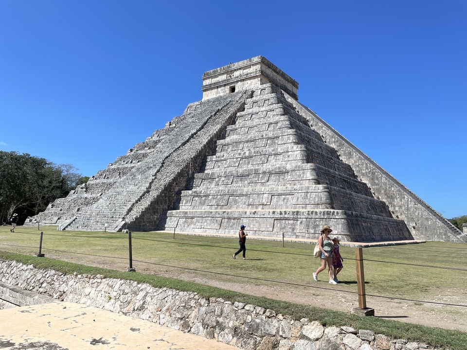 Tourists walking in front of Chichen Itza.