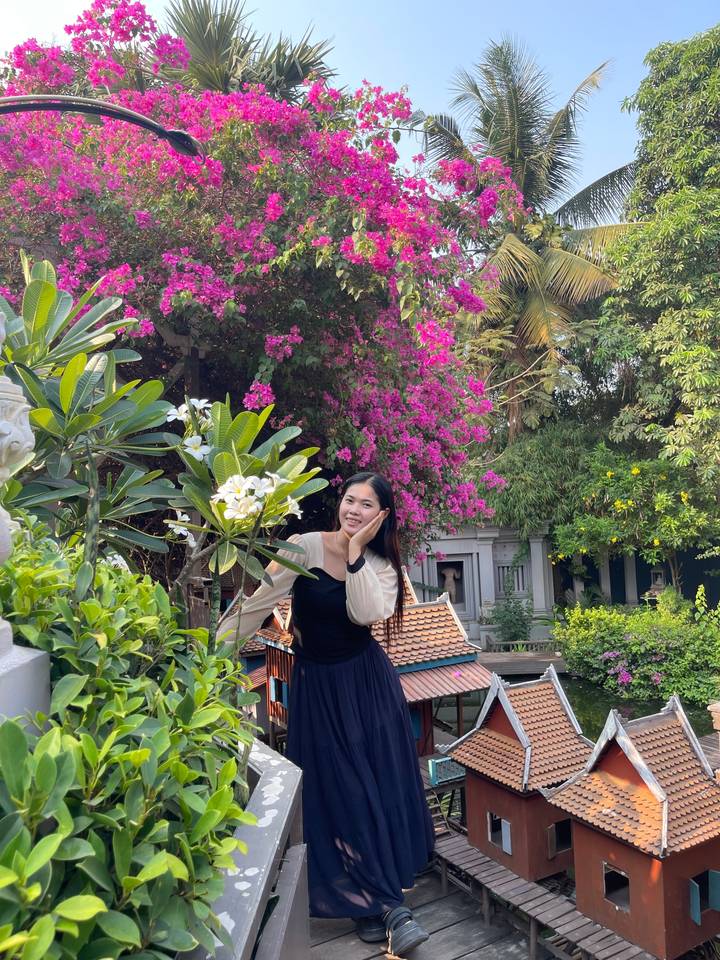 Woman posing near vibrant flowers and greenery