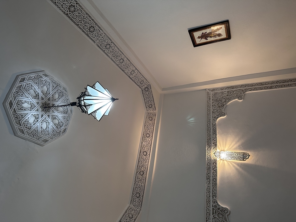 Ornate ceiling lamps with detailed wall carvings.