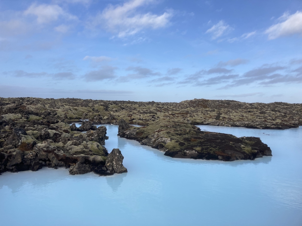 Scenic view of volcanic landscape with blue water pools.