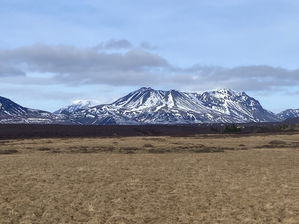 Snow-capped mountains under a partly cloudy sky.