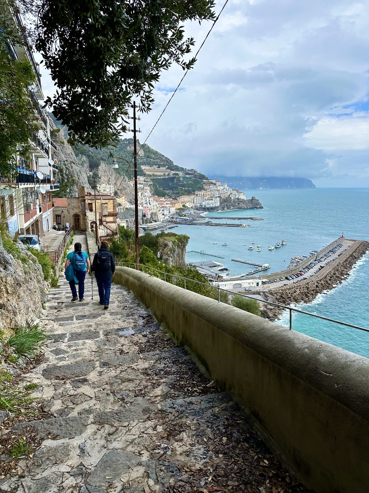 Coastal town with harbor and hills in the background.