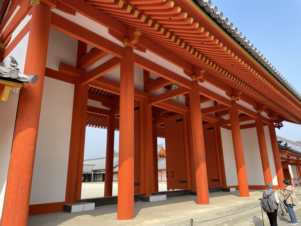 Porte d'entrée d'un temple avec des colonnes rouge vif.