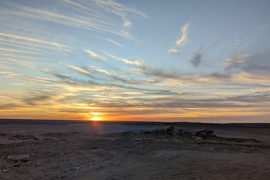 Sunset over a barren desert landscape.