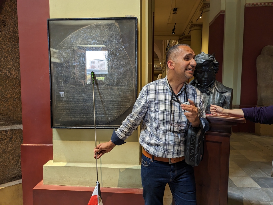 Guide speaking at a museum with ancient artifacts.