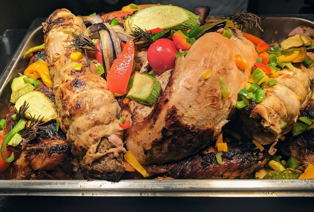 Roasted meat and vegetables in a tray.