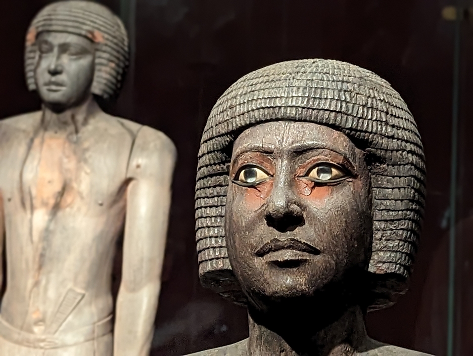 Ancient statues with expressive faces in a museum.