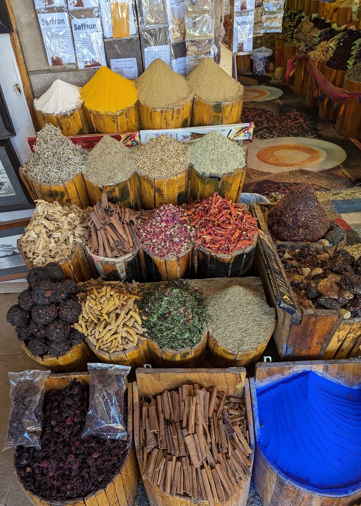 Display of various spices in a market setting.