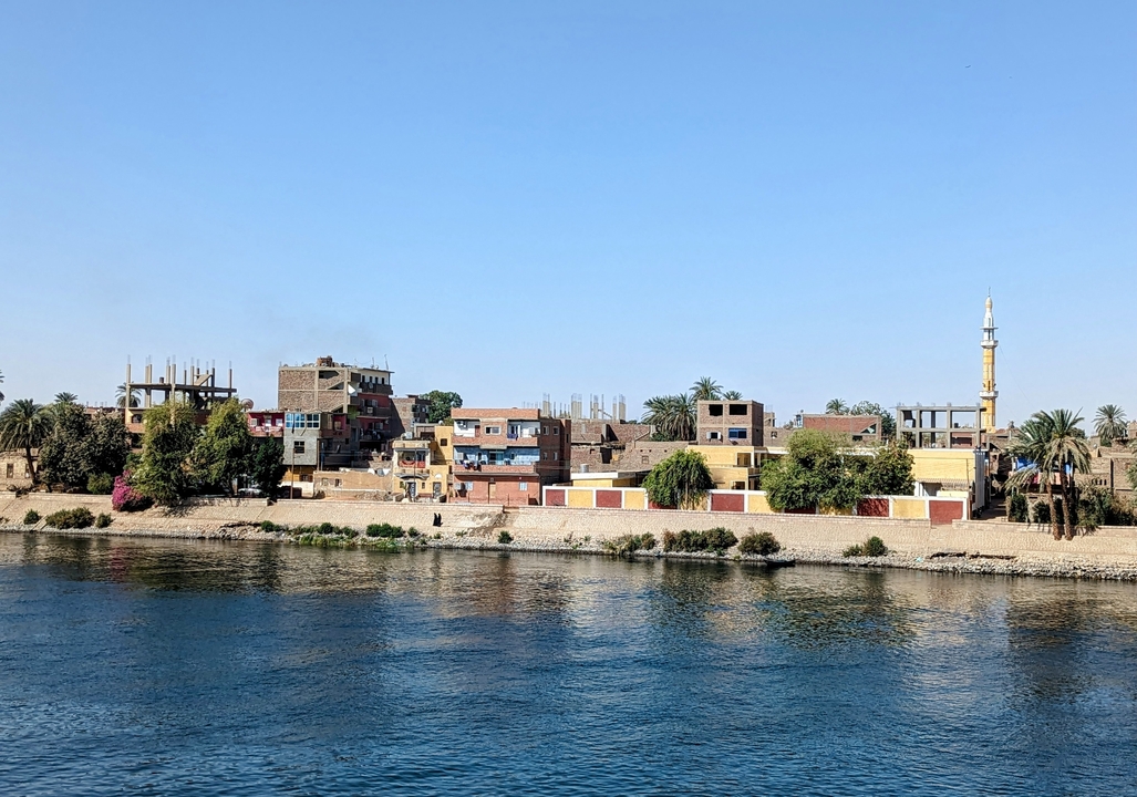 Colorful village buildings along a riverside.