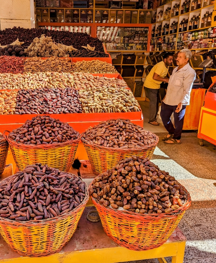Market scene with baskets of dates and spices.