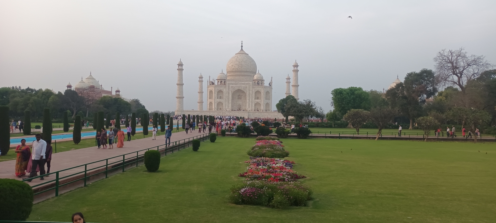 Le Taj Mahal avec ses jardins et ses visiteurs.