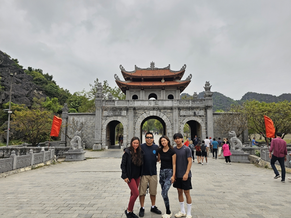 Groupe de personnes posant devant une porte d'entrée traditionnelle.