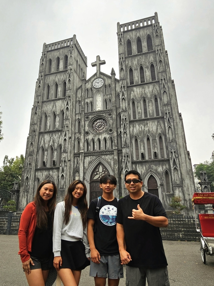 Groupe de personnes posant devant une grande cathédrale de style gothique.