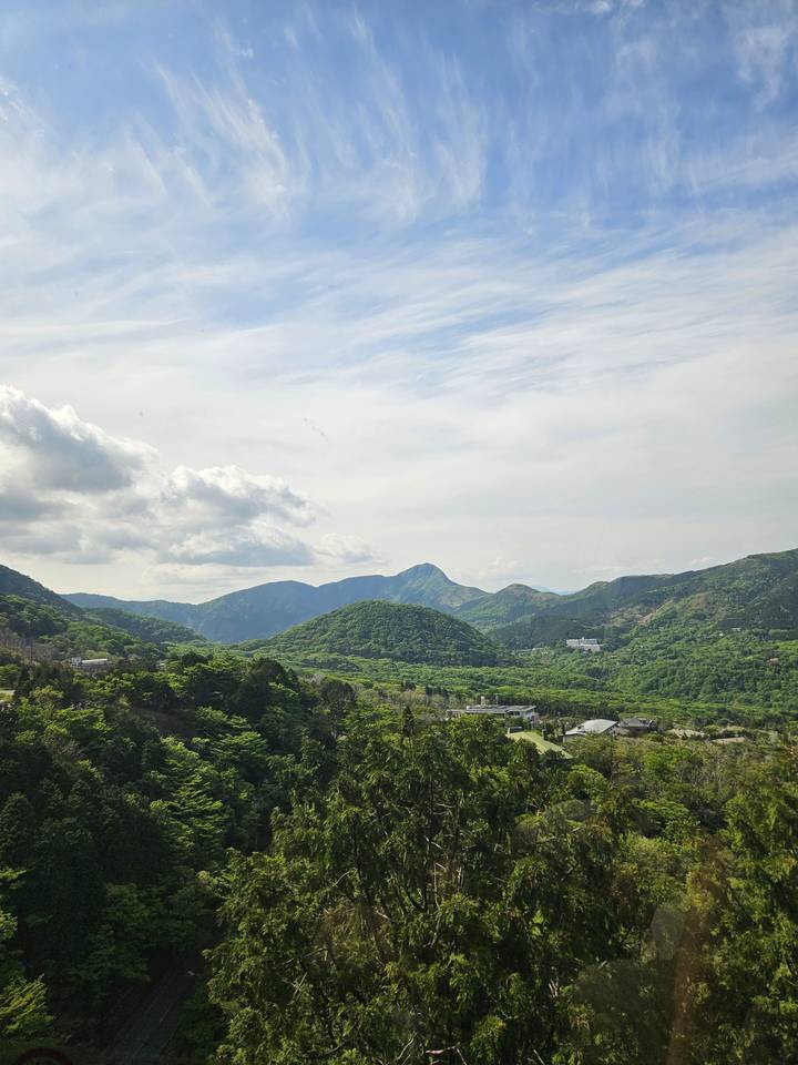 A landscape view showing distant mountains under a sparse cloudy sky.