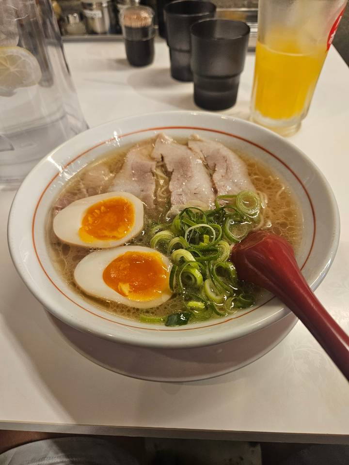 Bowl of ramen with boiled eggs and slices of meat.