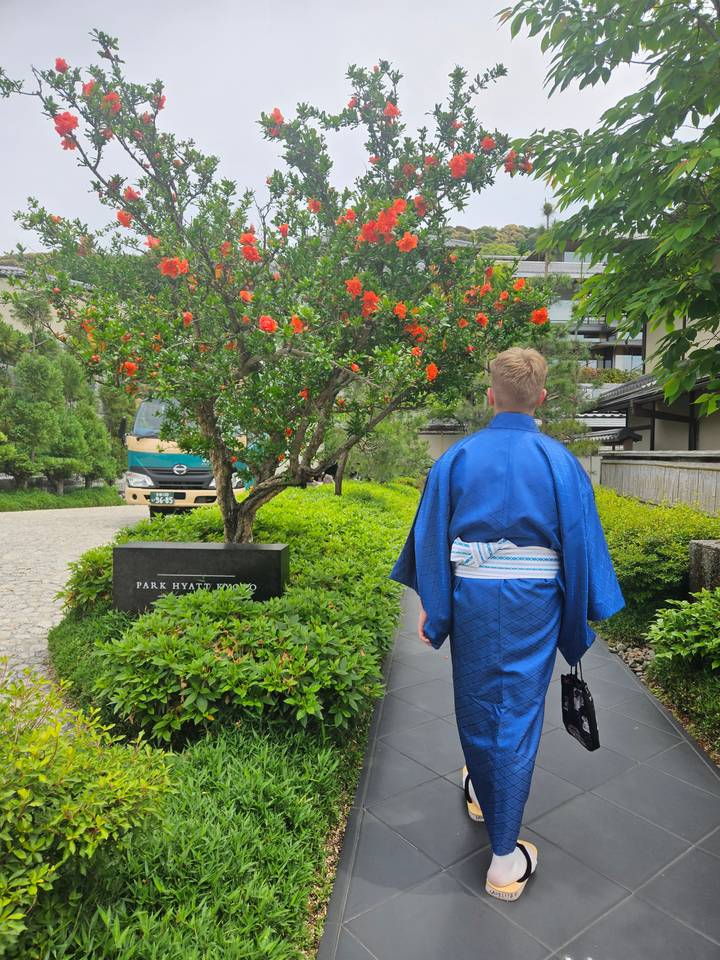 Person in traditional Japanese attire in a garden.
