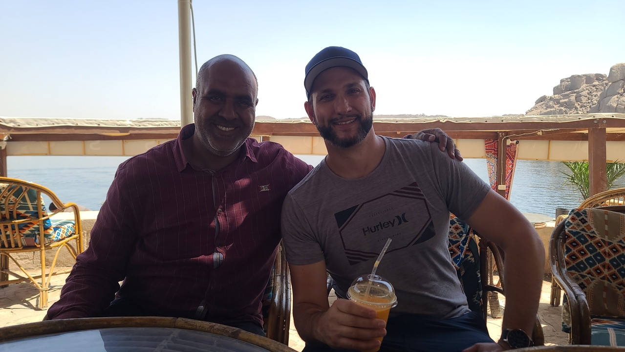 Two men sitting at a table with a view of the Nile.