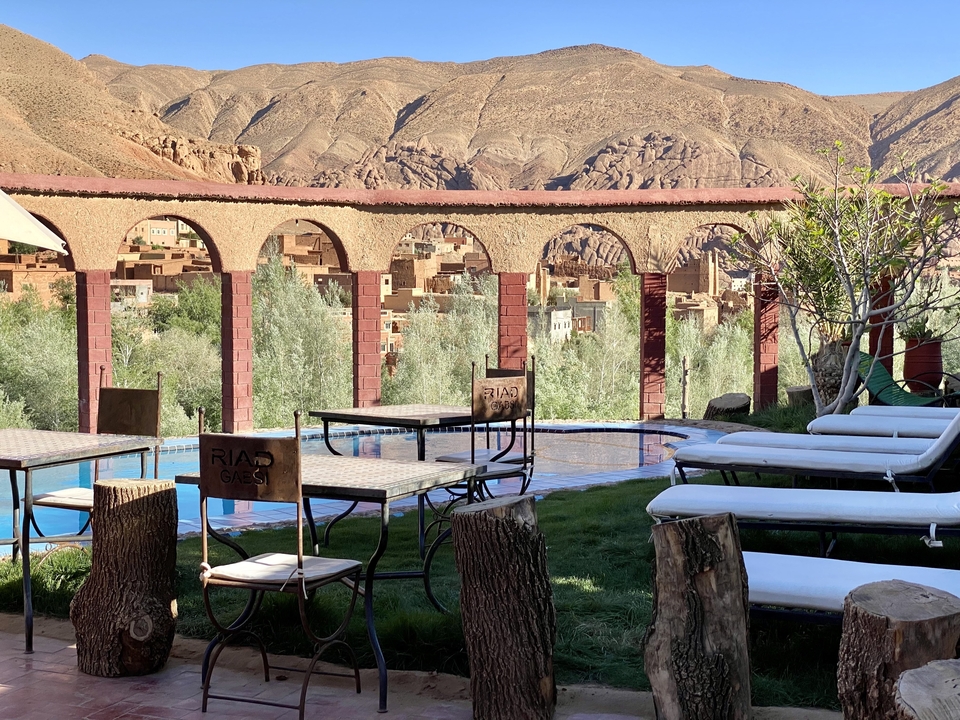 Outdoor seating area by a pool with mountain views.