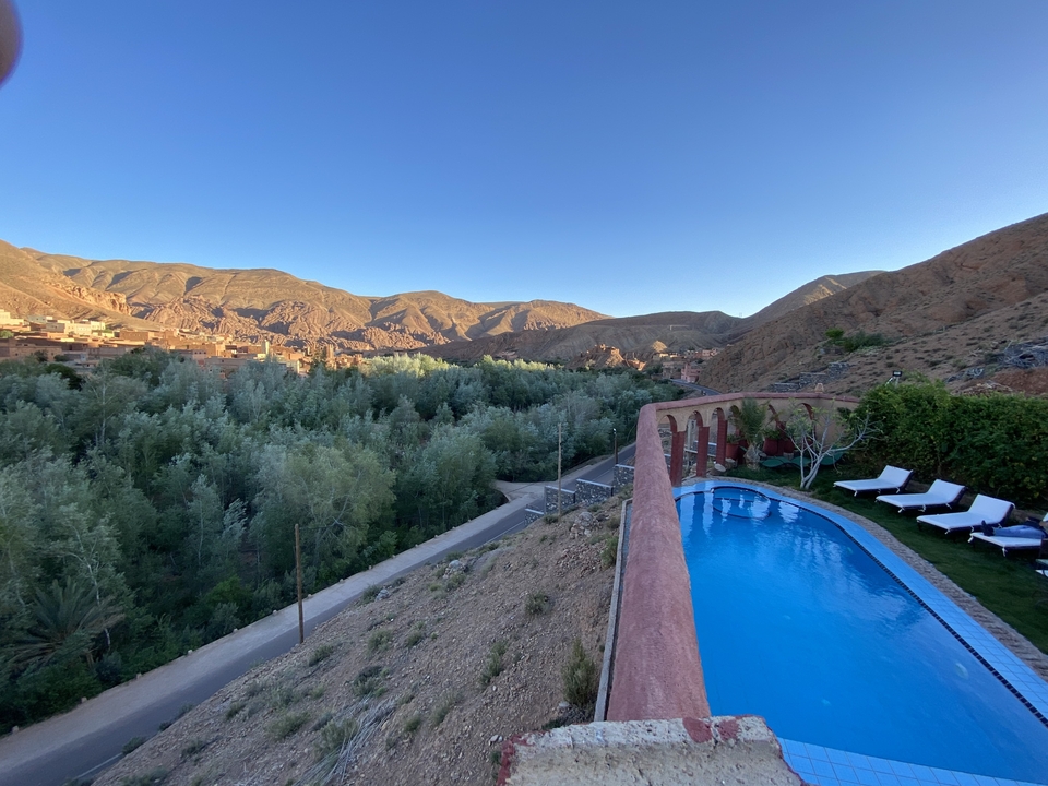 Pool overlooking a valley with mountains in the background.