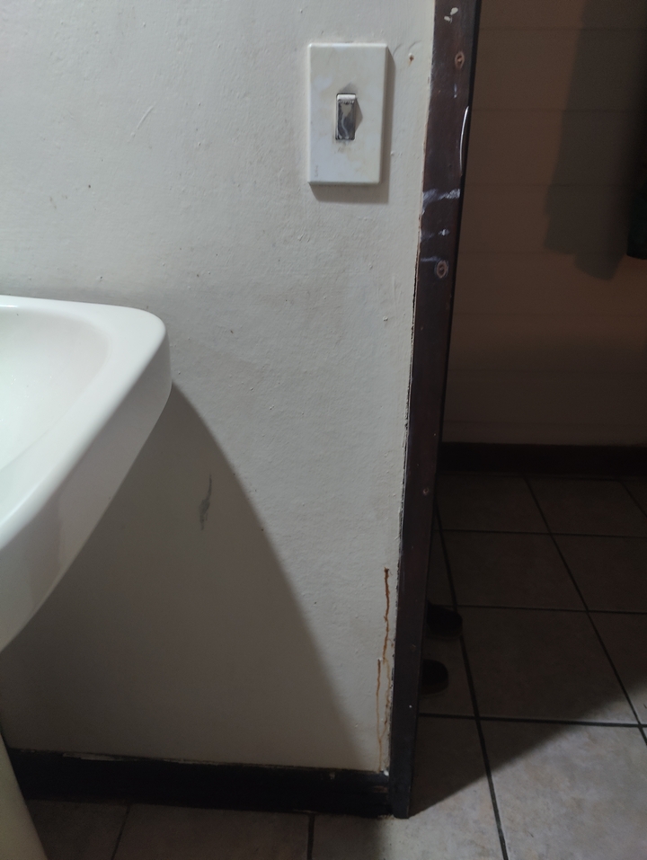 Wall corner with a sink partially visible.