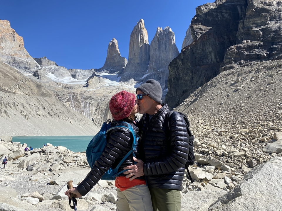 Couple kissing in front of iconic mountain peaks.