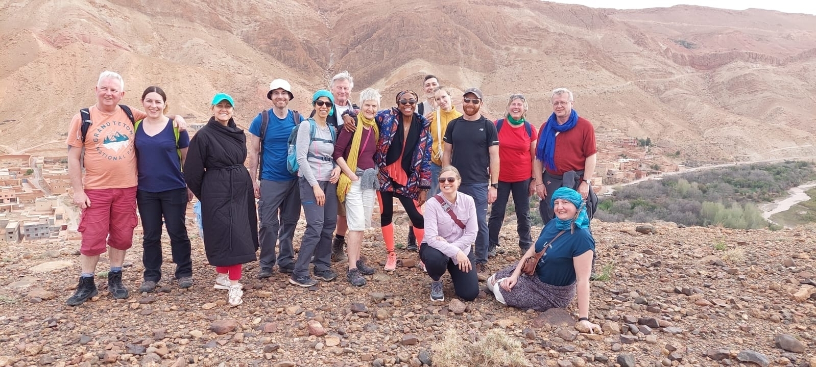 Groupe de personnes en tenue de randonnée debout dans un paysage rocheux.
