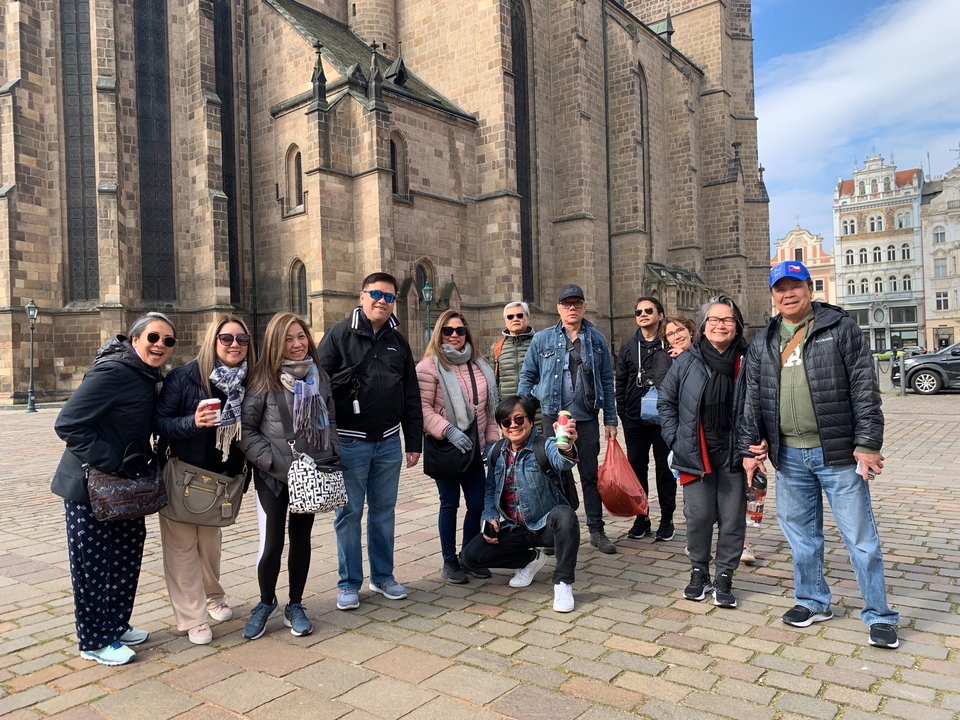 A group of tourists standing in front of a historic building.